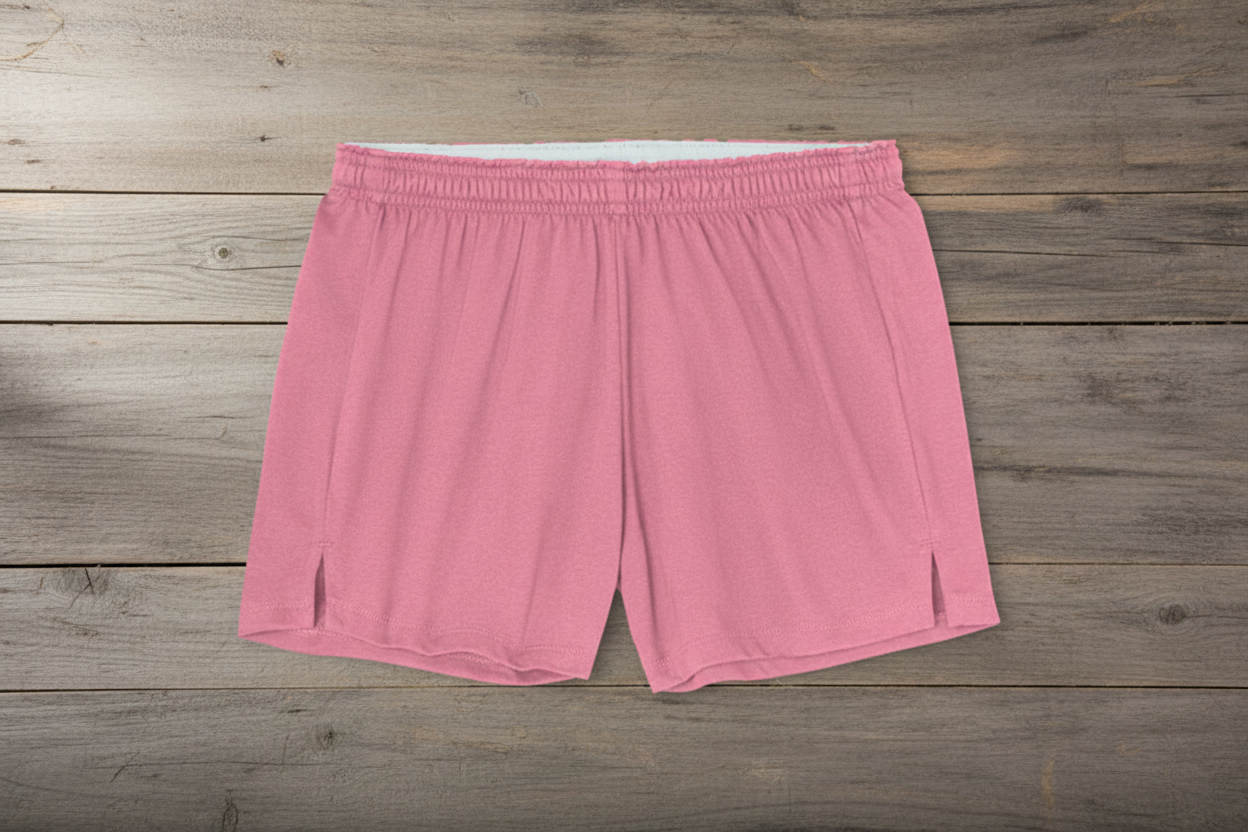 Pink athletic shorts on wooden background